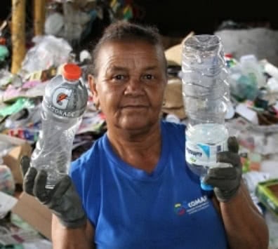 Brazilian waste picker holds up bottles