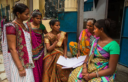Ahmedabad, India: Neighbourhood women gather outside their homes to discuss the area upkeep and work issues.