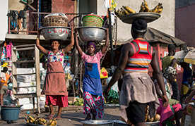 Kayayei carry a load full of goods on their heads at Agbogbloshie Market in Accra, Ghana