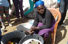 Coura Ndiaye, a leader of Bokk Diom, washing bottles at the Mbeubeuss dump in Dakar, Senegal in January 2017