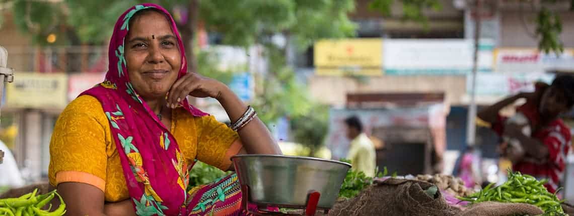Choral Mauladia poses near her cart where she sells vegetables at a local market
