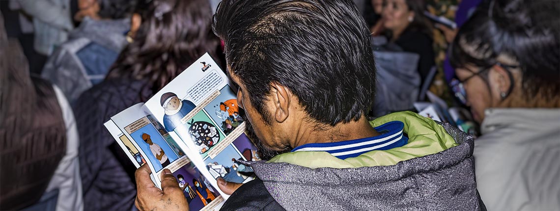 Waste picker reads the comic book created for the Los Rifados campaign