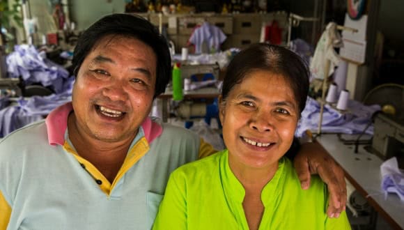 Amorn Harintornsutti(left) and his wife Wanpen pose in front of their small clothing factory