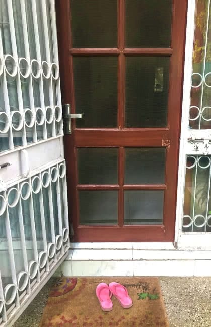 Domestic worker's slippers outside a door in Delhi