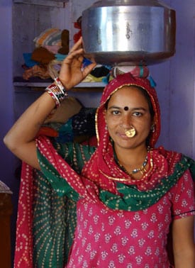 Devi-ben at home carrying a pot