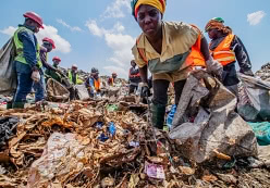 Récupératrice de matériaux dans un site de décharge à Accra