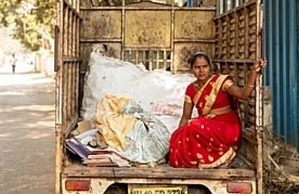 woman waste picker in collection truck, Pune, India