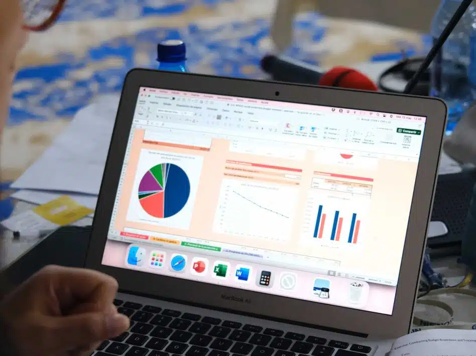WIEGO demonstrates an online tool for calculating social protection financing, with financial charts and graphs visible on a laptop screen